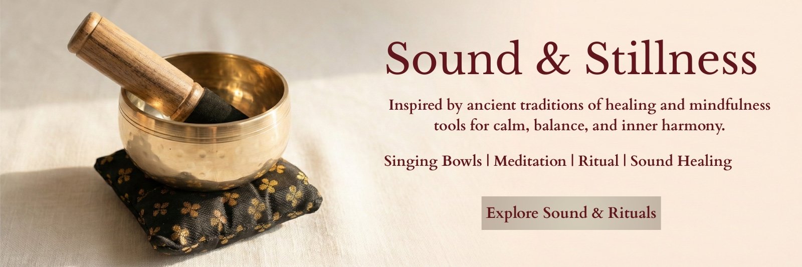 Handcrafted brass singing bowl with striker resting on decorative cushion.