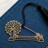 Charkha brass bookmark on blue book with khadi thread spool, Indian heritage inspired gift