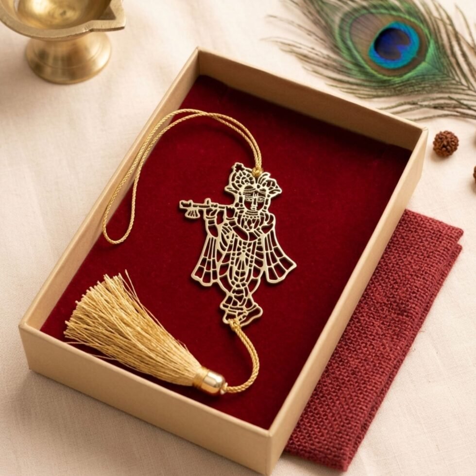 Gold polished brass Krishna hanging decor placed inside a gift box with barn red fabric lining and tassel.