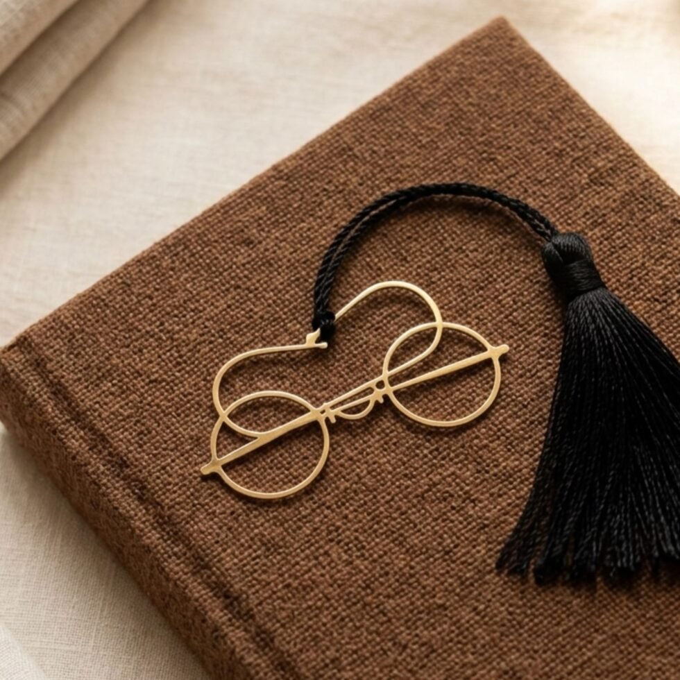 Gold plated Gandhi spectacles bookmark with black tassel on brown jute fabric book, unique handmade gift for readers